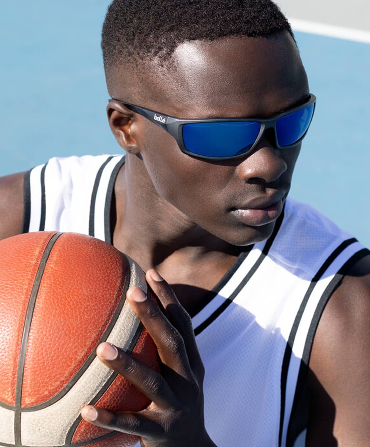 sportowiec czyści soczewki okularów po treningu na siłowni z hantlami w tle